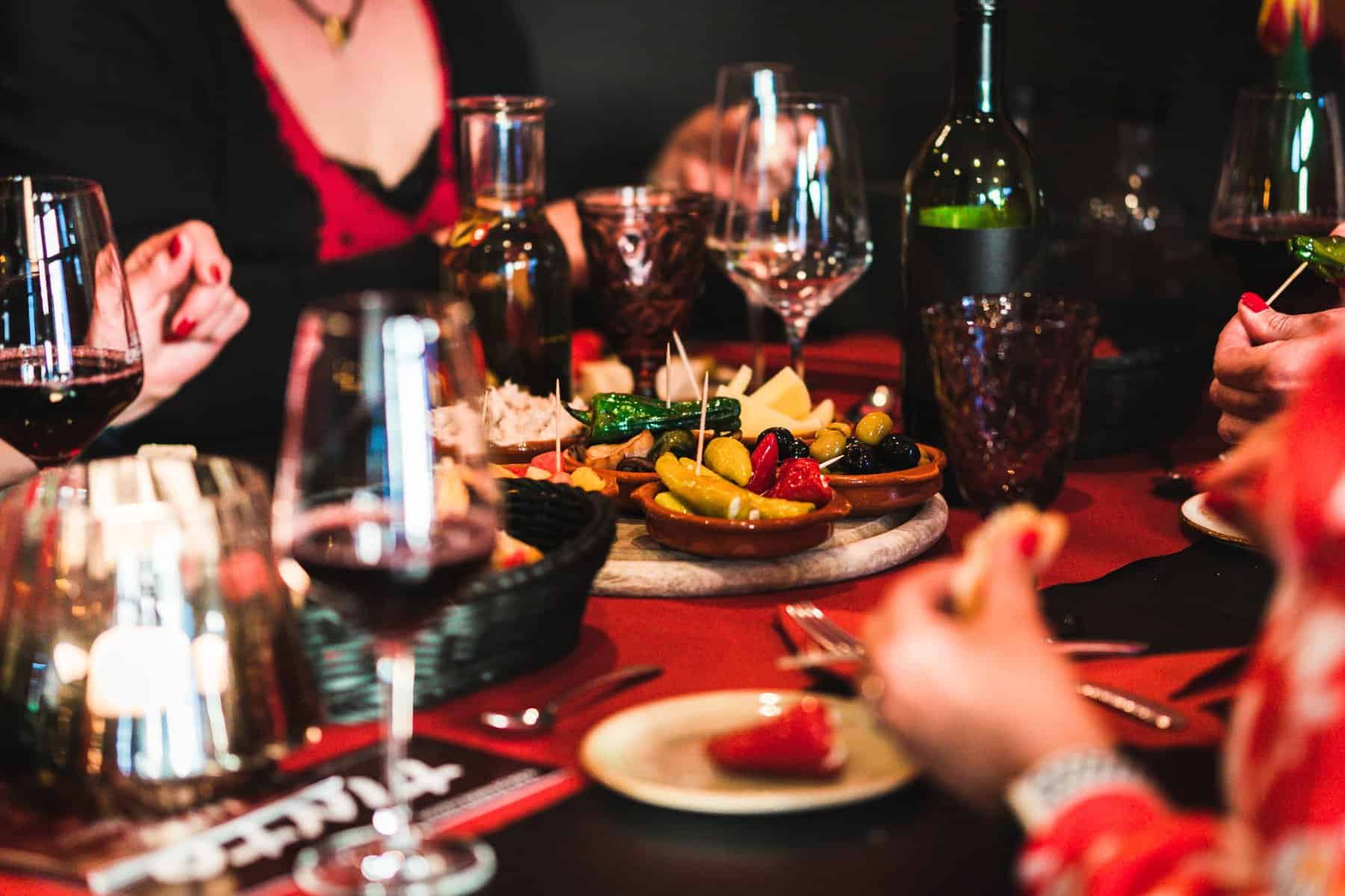 People eating Tapas at a Tapas Bar with food and drinks on the table