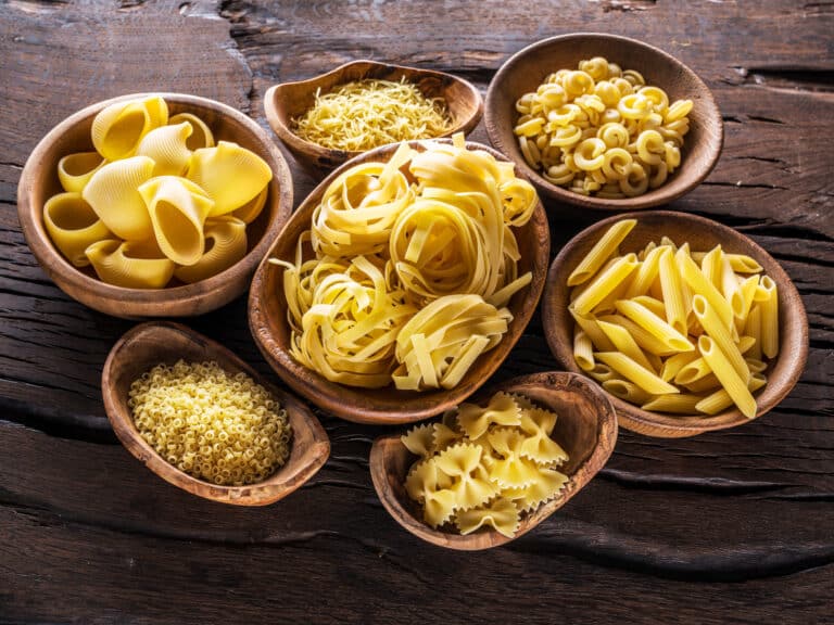 Pasta i Italien. Different pasta types in wooden bowls on the table.