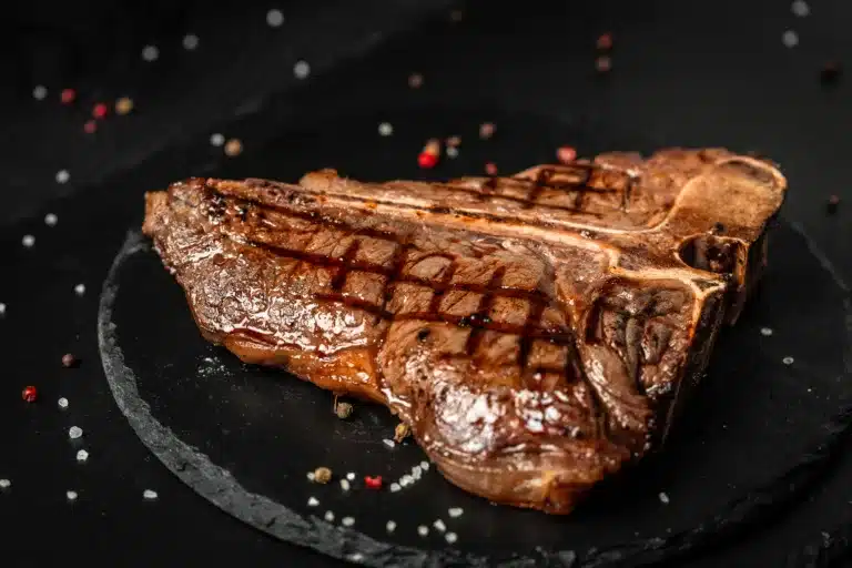 Barbecue Porterhouse Steak T-bone beef steak sliced with large fillet piece with herbs and salt.