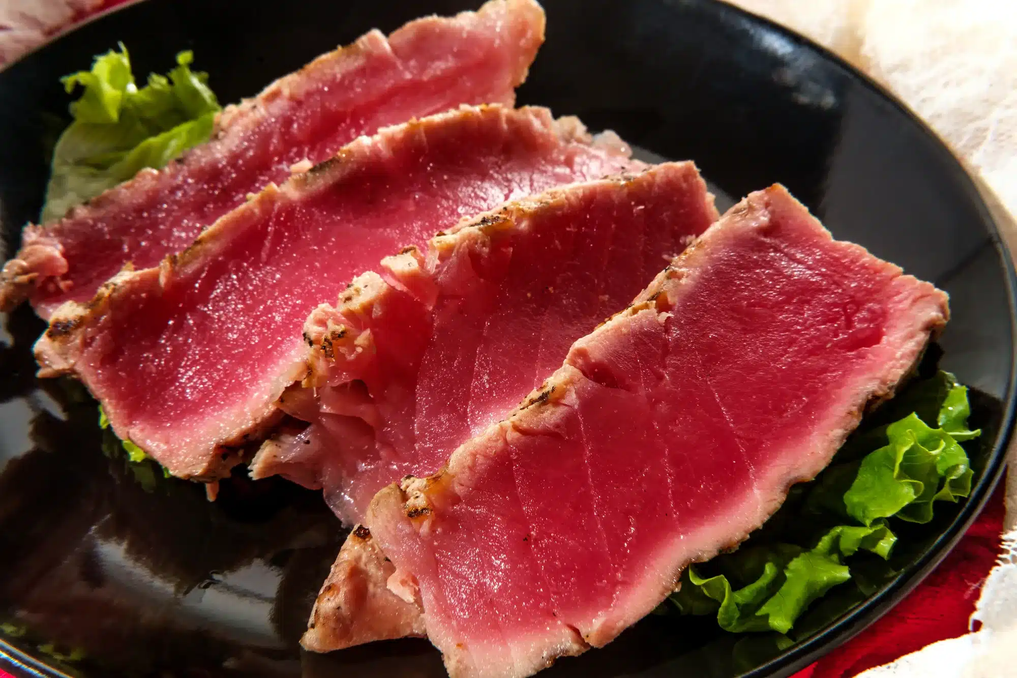 Seared ahi tuna with grill marks sliced to reveal tender pink raw inside